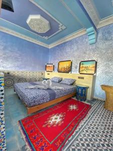 阿格魯的住宿－Taddart Aglou，一间卧室配有一张床和红色地毯