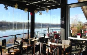 um restaurante com mesas e cadeiras e vista para um lago em Cozy suite close to Nature and the City em Maple Ridge