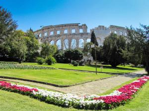 a park with flowers in front of the coliseum at Holiday home in Pula/Istrien 17365 in Štinjan
