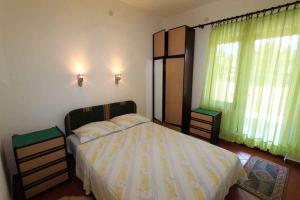 um quarto com uma cama e 2 janelas com cortinas verdes em Silo Apartment 8 em Šilo