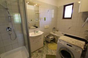 a bathroom with a washing machine and a washer at Silo Apartment 8 in Šilo