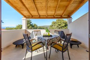 a dining room with a table and chairs on a balcony at Apartment Vesna in Milna