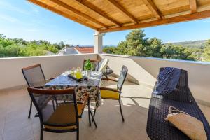 a patio with a table and chairs on a balcony at Apartment Vesna in Milna