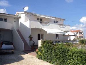 a white house with a car parked in front of it at Apartment in Vodice 7702 in Vodice