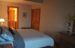 a bedroom with a white bed and a wooden door at Cozy 2 bedrooms condo with stunning Mont Tremblant mountain and lakeview in Mont-Tremblant