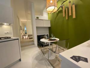 una cocina con una mesa pequeña y una pared verde en Home3 beb appartments, en Bisceglie