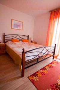 a bedroom with a large bed with orange pillows at Apartment Vrbnik 6 in Vrbnik