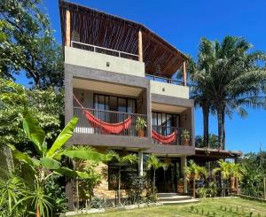 a building with a balcony and palm trees at Recantos do Dende in Itacaré