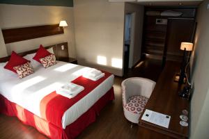 Habitación de hotel con cama y escritorio de madera. en First Palermo Hotel en Buenos Aires