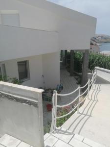 a white house with a fence on a patio at Big Blue - Xenija (Veliko Plavetnilo - Ksenija) in Metajna