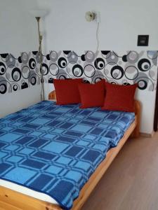 レーヴフュロップにあるHoliday home in Revfülöp/Balaton 19622のベッドルーム1室(青いベッド1台、赤い枕付)