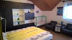 a bedroom with a bed and a couch and a chair at Apartment in Balatonkenese - Balaton 18978 in Balatonkenese