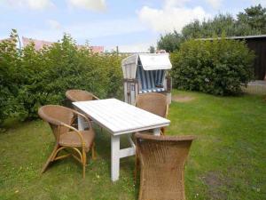a white table and chairs in a yard at Apartment Altenkirchen 4 in Altenkirchen