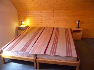 a bed in a wooden room with two night stands at Apartment in Balatonbereny/Balaton 18075 in Balatonberény