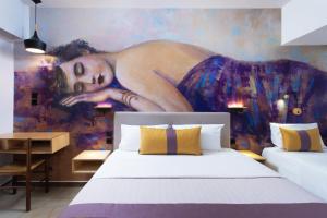 a bedroom with a painting of a woman on the wall at Monemvasia Green Apartments in Monemvasia