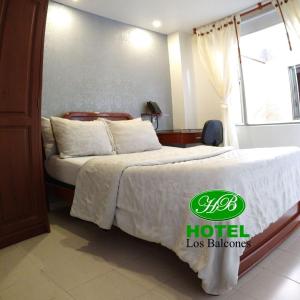 una habitación de hotel con una cama con un cartel. en HOTEL LOS BALCONES, en Bogotá