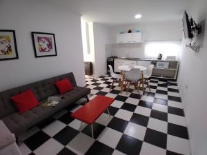 a living room with a couch and a checkered floor at Cabañas Terruños de Pilar in Malargüe