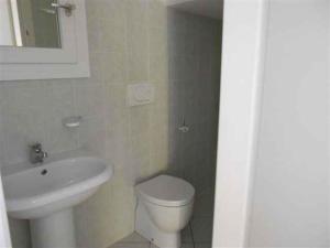 y baño con aseo blanco y lavamanos. en Holiday Homes in Rosolina Mare 24977, en Rosolina Mare
