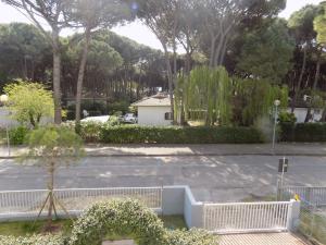 ein leerer Parkplatz mit einem Zaun und Bäumen in der Unterkunft Apartment in Eraclea Mare 25161 in Eraclea Mare