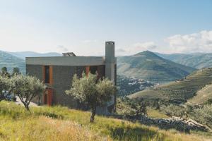 un bâtiment sur le côté d'une colline plantée d'arbres dans l'établissement Casa do Arco by Douro Exclusive, à São Cristóvão do Douro