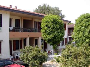 un edificio con muchos árboles delante de él en Apartments in Rosolina Mare 24851, en Rosolina Mare