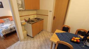 a small kitchen with a table and a room with a bed at Apartment Porat 22 in Porat