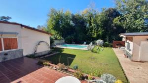 een achtertuin met een zwembad en een tuin bij Teilen in Villa General Belgrano