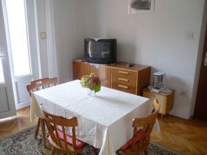 a dining room table with a vase of flowers on it at Apartment in Kampor/Insel Rab 16142 in Kampor