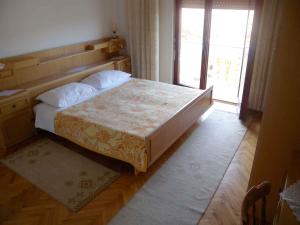 a bedroom with a large bed with a large window at Apartment in Kampor/Insel Rab 16142 in Kampor