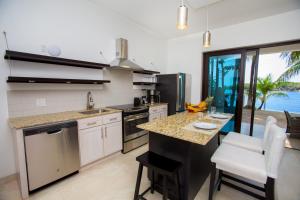 a kitchen with a counter and a table with chairs at Bella Luna Beach Condo #227462 in West End