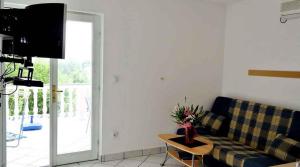 salon z kanapą i stołem w obiekcie Apartment Silo 3 w mieście Šilo