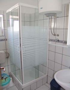 a glass shower in a bathroom with a sink at Apartment Silo 3 in Šilo