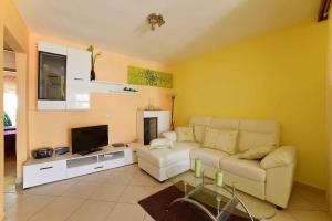 ein Wohnzimmer mit einem Sofa und einem TV in der Unterkunft Apartment Pula, Istria Country 1 in Vintijan