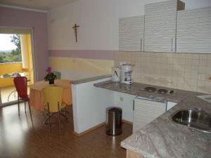 uma cozinha com um balcão e uma mesa com cadeiras em Apartment Liznjan 5 em Ližnjan