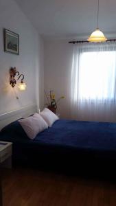 a bedroom with a blue bed with a window at Holiday home in Premantura - Istrien 10653 in Premantura