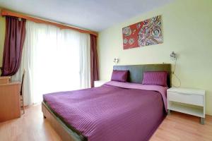 a purple bed in a bedroom with a window at Apartment Pula 15 in Vintijan