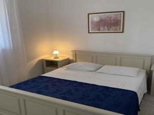 1 dormitorio con 1 cama y 1 mesa con lámpara en Holiday home in Vela Luka 6375, en Vela Luka