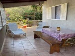 patio con mesa, sillas y ventana en Holiday home in Vela Luka 6375, en Vela Luka