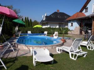 grupa krzeseł siedzących wokół basenu w obiekcie Holiday home in Balatonmariafürdo 19325 w mieście Balatonmáriafürdő