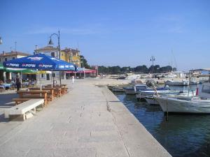 a marina with tables and umbrellas and boats in the water at Apartment Fazana, Istria 16 in Fažana