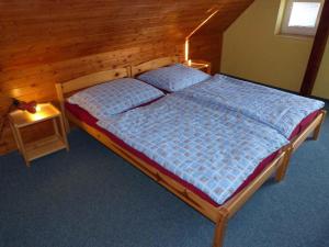 sypialnia z łóżkiem z drewnianą ścianą w obiekcie Holiday home Vrchlabi/Riesengebirge 2190 w mieście Podhŭří