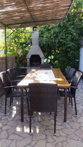 a wooden table and chairs with an outdoor fireplace at Holiday home in Premantura - Istrien 10653 in Premantura