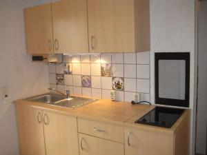a small kitchen with a sink and a mirror at Holiday home Kamminke/Insel Usedom 3203 in Kamminke