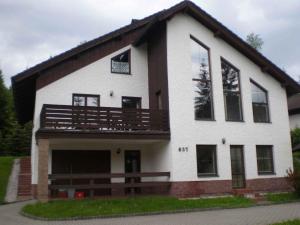 a large white house with a balcony at Apartment Harrachov 11 in Nový Svět