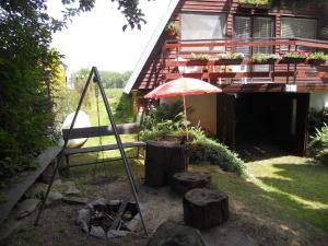 eine Terrasse mit einem Regenschirm und einigen Holzscheiten und einem Haus in der Unterkunft Holiday home in Stipoklasy 1175 in Bludov