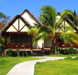 une maison avec un palmier en face dans l'établissement Playa Venao Hotel Resort, à Playa Venao