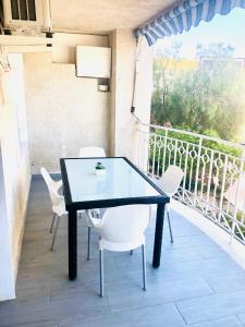 d'une table noire et de chaises blanches sur un balcon. dans l'établissement Apartamento Santa Pola"The Guitar" 300 m de la playa, à Santa Pola