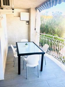 una mesa negra y sillas blancas en el balcón en Apartamento Santa Pola"The Guitar" 300 m de la playa, en Santa Pola