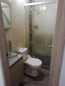 a bathroom with a toilet and a glass shower at Apartamento La Ceja in La Ceja