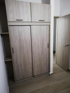 a closet with two wooden cabinets in a room at Apartamento La Ceja in La Ceja